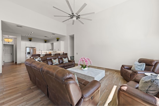 living room featuring ceiling fan and a towering ceiling