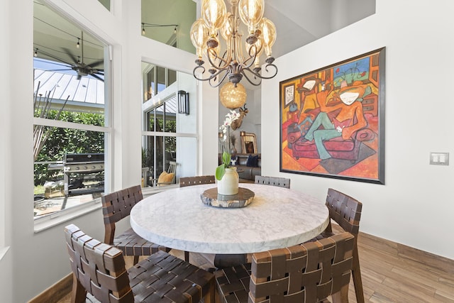 dining room featuring a wealth of natural light, hardwood / wood-style floors, and ceiling fan with notable chandelier