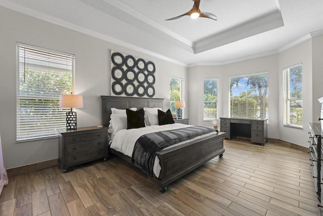 bedroom with ceiling fan, ornamental molding, and a tray ceiling