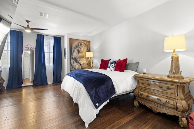 bedroom featuring ceiling fan, dark hardwood / wood-style floors, and multiple windows