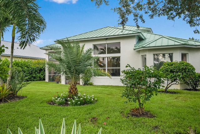 rear view of house featuring a lawn