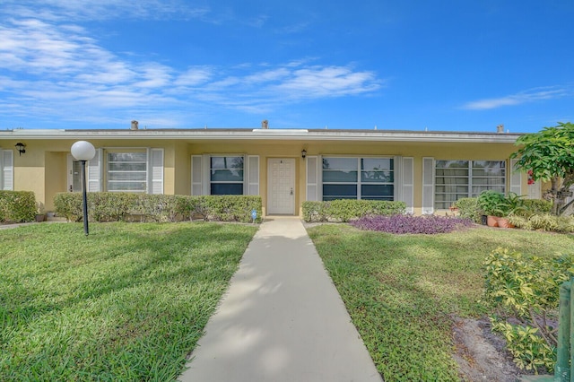 single story home with a front lawn