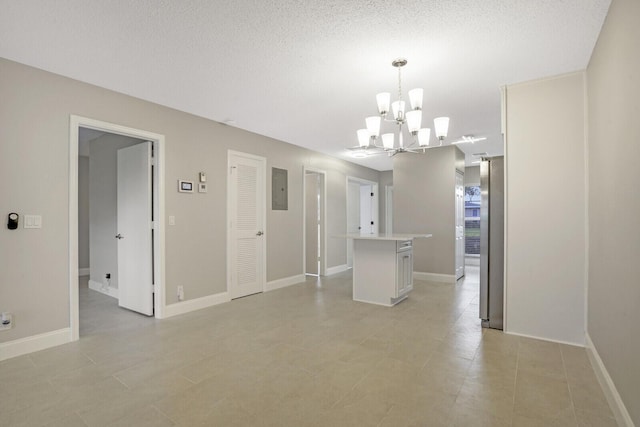 unfurnished dining area featuring light tile patterned floors, a textured ceiling, electric panel, and an inviting chandelier