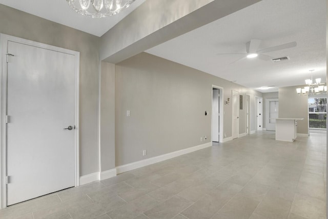 spare room with light tile patterned floors and ceiling fan with notable chandelier