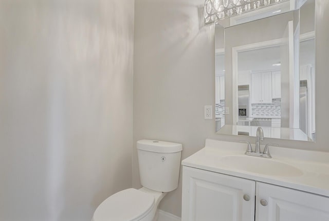 bathroom featuring decorative backsplash, vanity, and toilet