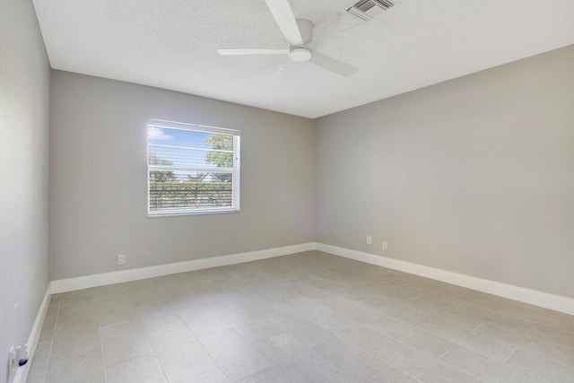 unfurnished room with ceiling fan and a textured ceiling