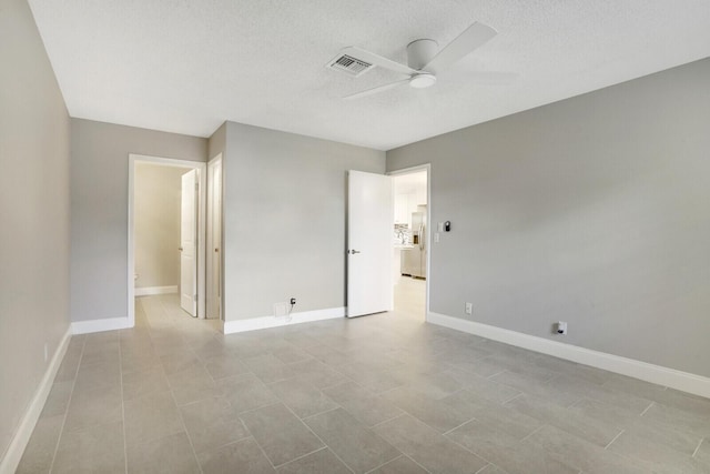 unfurnished room featuring ceiling fan, light tile patterned floors, and a textured ceiling