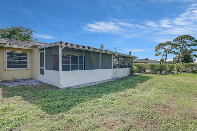 view of property exterior featuring a sunroom and a yard