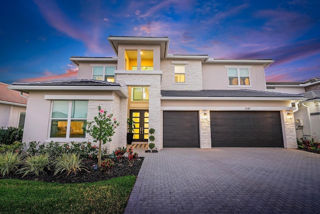 prairie-style house featuring a garage and french doors