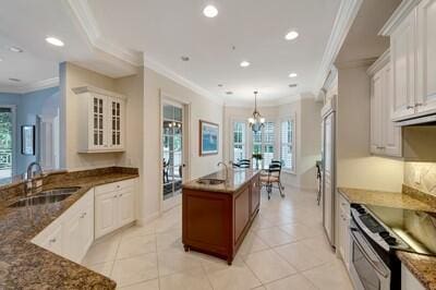 kitchen with white cabinetry, sink, appliances with stainless steel finishes, and ornamental molding