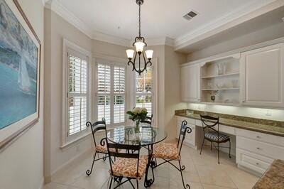 tiled dining room featuring built in desk, crown molding, and a chandelier