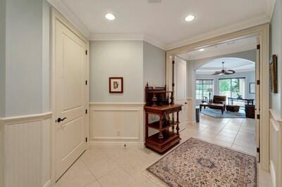 hall featuring light tile patterned floors and ornamental molding