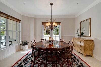 dining room featuring french doors, a wealth of natural light, crown molding, and a notable chandelier