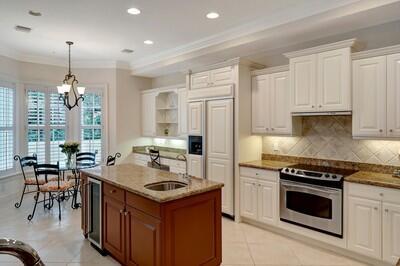 kitchen featuring stainless steel range with electric stovetop, sink, light tile patterned floors, white cabinets, and hanging light fixtures