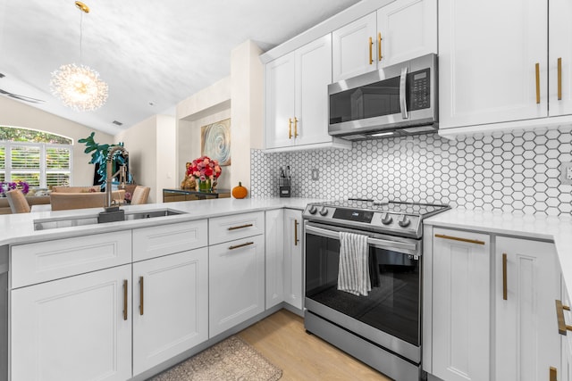 kitchen featuring backsplash, white cabinetry, light wood-type flooring, and appliances with stainless steel finishes