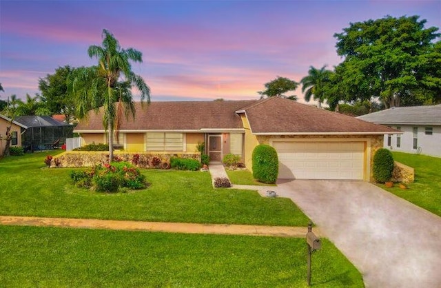 ranch-style home with a yard and a garage