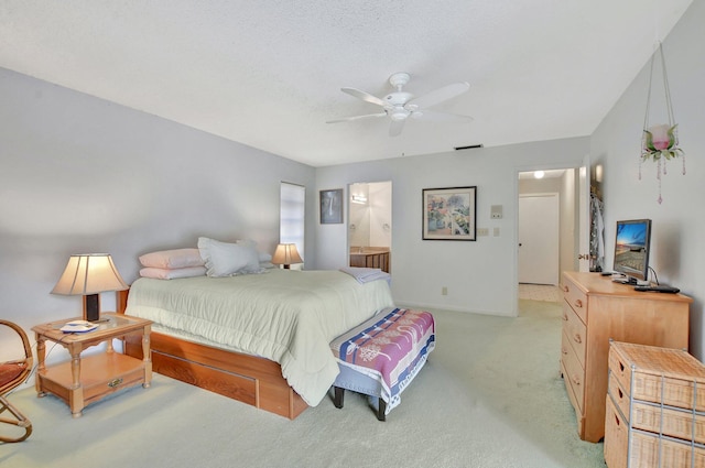 bedroom with a textured ceiling, ceiling fan, light colored carpet, and ensuite bathroom