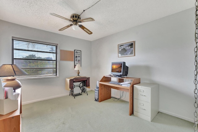 carpeted office featuring ceiling fan and a textured ceiling