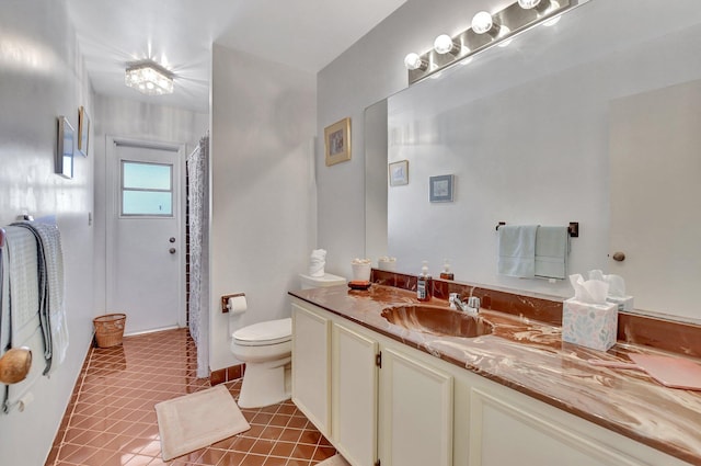 bathroom with tile patterned flooring, vanity, and toilet