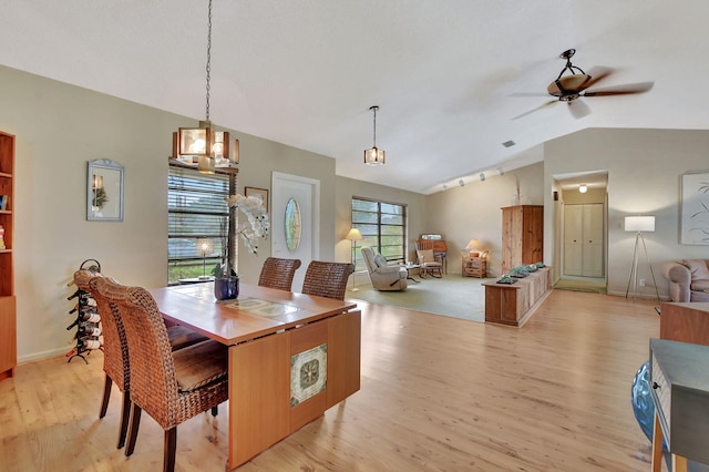 dining area with ceiling fan, lofted ceiling, and light hardwood / wood-style floors