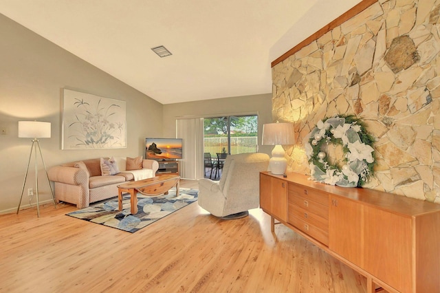 living room with light hardwood / wood-style floors and vaulted ceiling