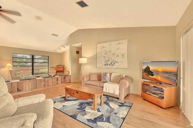 living room featuring ceiling fan, light hardwood / wood-style floors, and vaulted ceiling