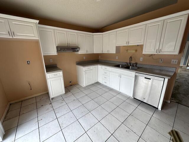 kitchen with dishwasher, sink, white cabinets, and a textured ceiling