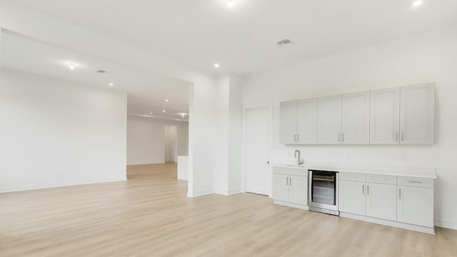 interior space with sink, beverage cooler, and light wood-type flooring