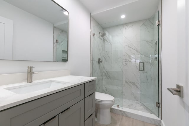 bathroom featuring vanity, toilet, and a shower with shower door