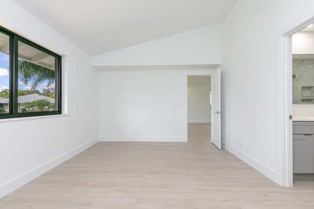 empty room featuring light hardwood / wood-style flooring and lofted ceiling