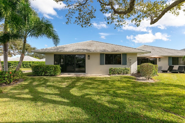 rear view of property featuring a lawn