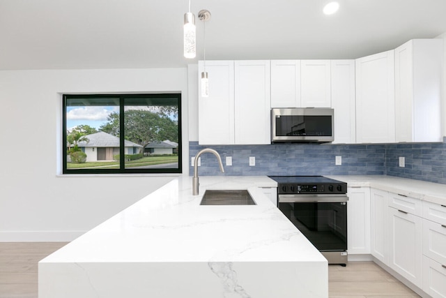 kitchen with white cabinetry, sink, decorative light fixtures, and appliances with stainless steel finishes