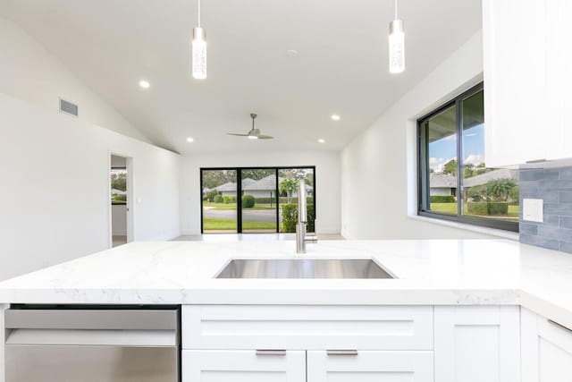 kitchen with pendant lighting, decorative backsplash, stainless steel dishwasher, and white cabinets