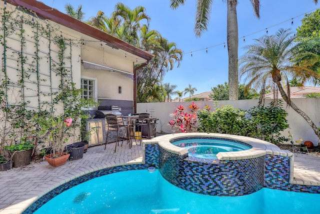 view of pool with a patio, area for grilling, a fenced backyard, and a pool with connected hot tub