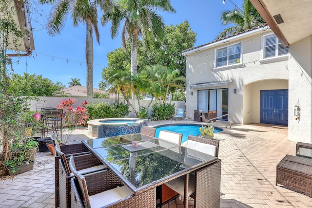 view of swimming pool featuring a patio, a fenced backyard, and a pool with connected hot tub