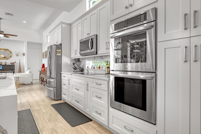 kitchen featuring light wood-type flooring, visible vents, tasteful backsplash, stainless steel appliances, and ceiling fan