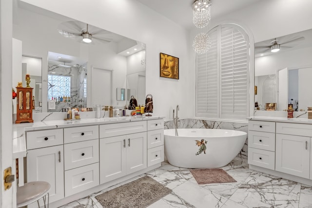 bathroom featuring marble finish floor, a freestanding bath, and a ceiling fan