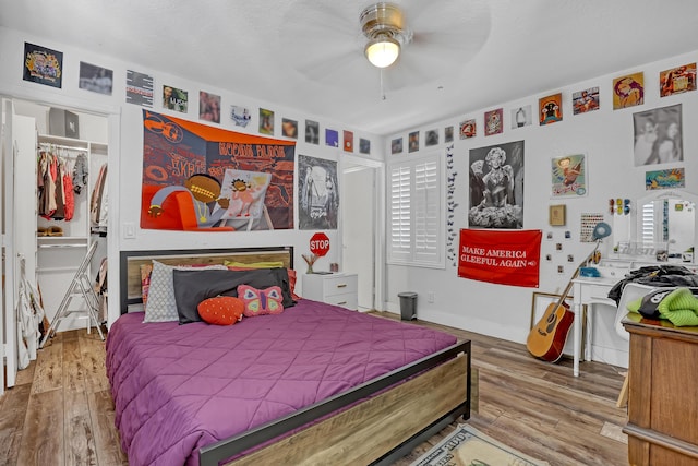 bedroom with baseboards, wood finished floors, and a ceiling fan