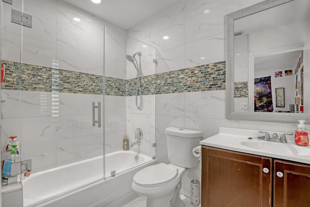 full bathroom featuring bath / shower combo with glass door, tile walls, vanity, and toilet