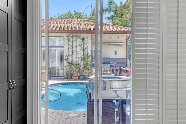 view of pool with a pool with connected hot tub