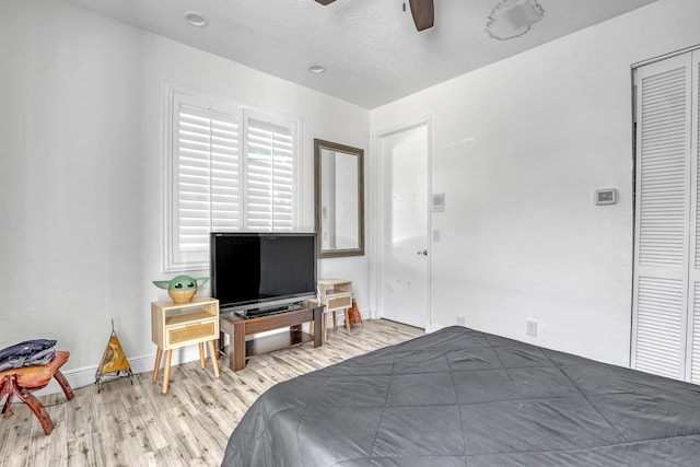 bedroom featuring wood finished floors, baseboards, a closet, and ceiling fan