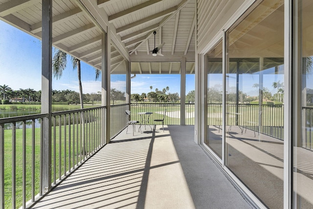 unfurnished sunroom with vaulted ceiling with beams and a water view