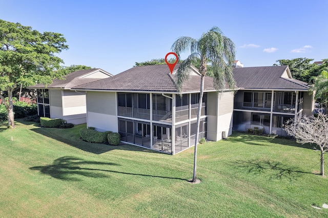 rear view of property featuring a lawn