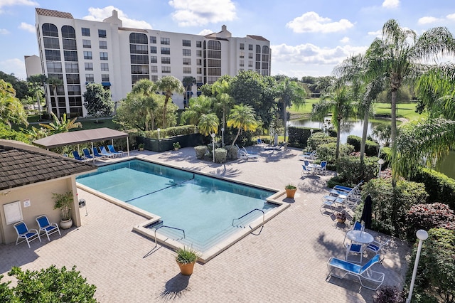 view of swimming pool featuring a patio and a water view