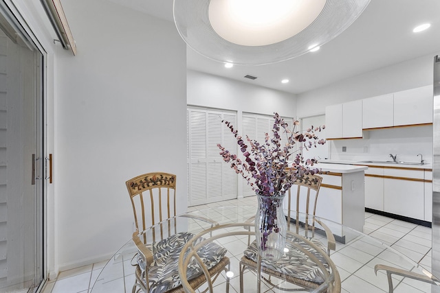 dining space featuring sink and light tile patterned flooring