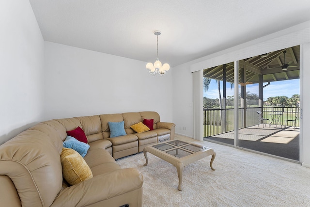 carpeted living room featuring a notable chandelier