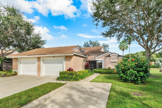 single story home featuring a garage and a front lawn