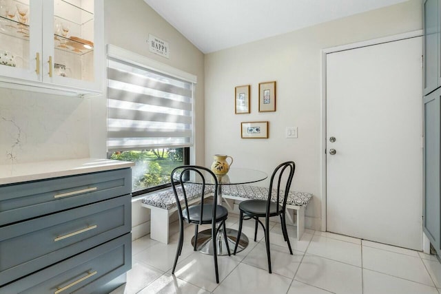 tiled dining space with lofted ceiling