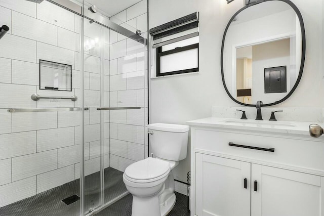 bathroom with vanity, toilet, and a shower with shower door