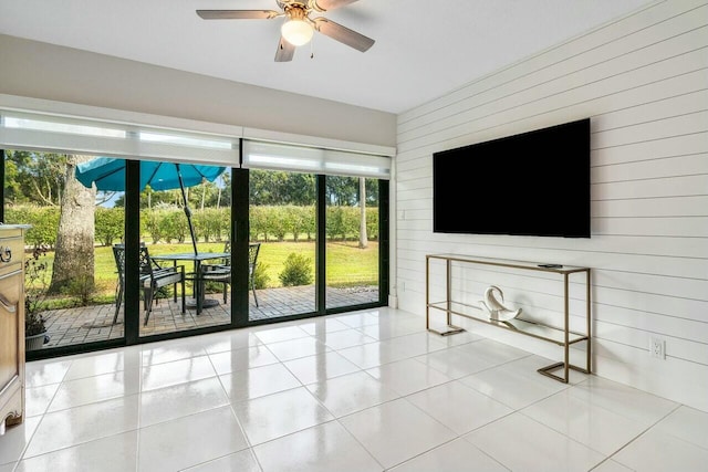 unfurnished living room featuring ceiling fan and light tile patterned floors